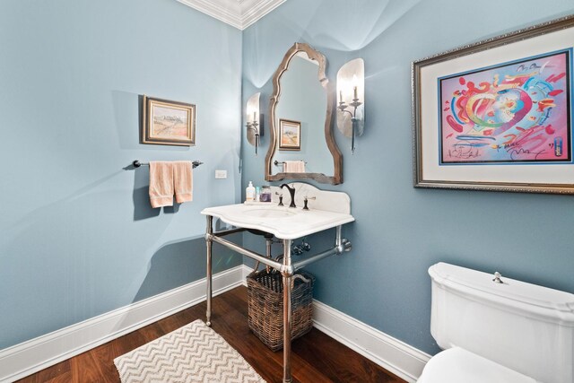 bathroom featuring wood-type flooring, toilet, and ornamental molding