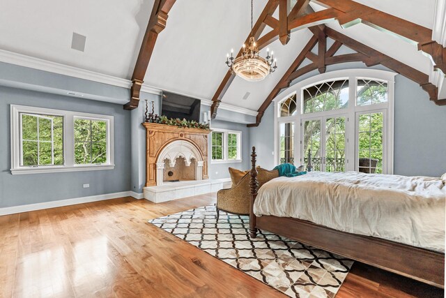 bedroom featuring multiple windows, beamed ceiling, and light hardwood / wood-style flooring