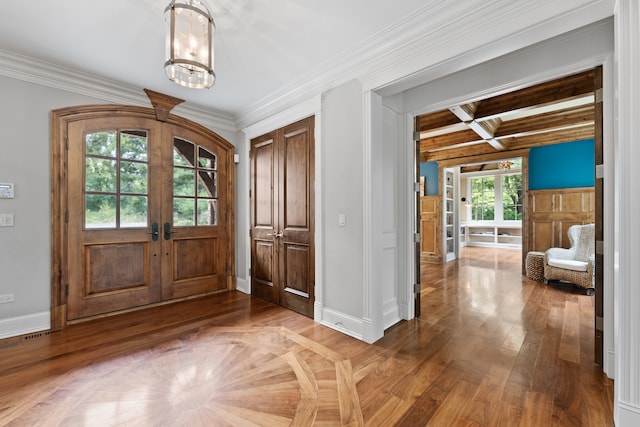 entrance foyer featuring hardwood / wood-style flooring, an inviting chandelier, french doors, beamed ceiling, and ornamental molding