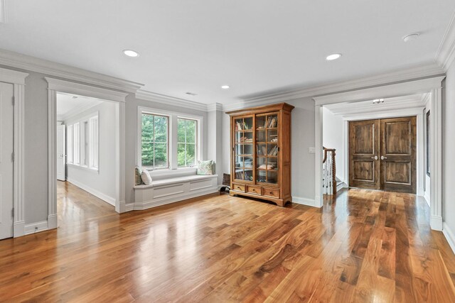 unfurnished living room with crown molding and hardwood / wood-style flooring