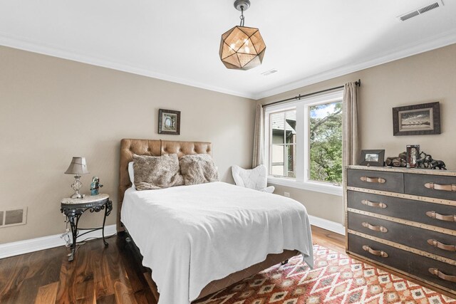 bedroom with crown molding and dark wood-type flooring