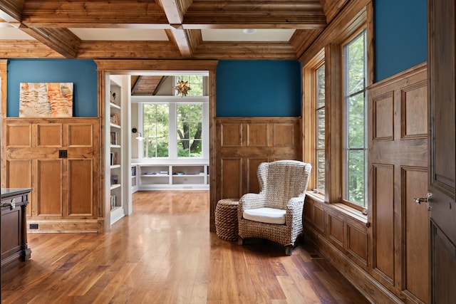 sitting room featuring a wealth of natural light, dark wood-type flooring, coffered ceiling, and beamed ceiling