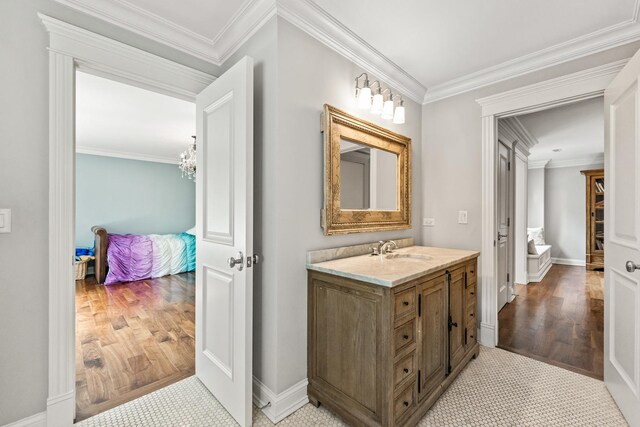 bathroom with crown molding, vanity, and wood-type flooring