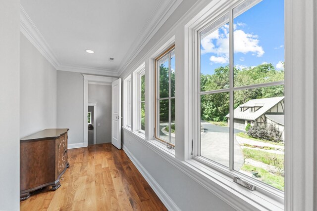 hallway featuring ornamental molding and hardwood / wood-style floors