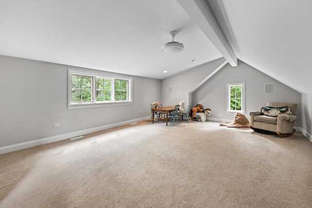 living area with lofted ceiling with beams and carpet flooring