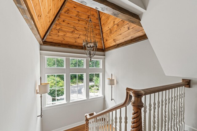 stairs with wood ceiling, a notable chandelier, and hardwood / wood-style flooring