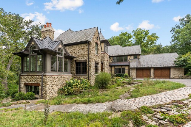 english style home featuring a garage