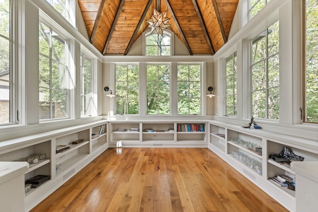 unfurnished sunroom with vaulted ceiling with skylight and wooden ceiling