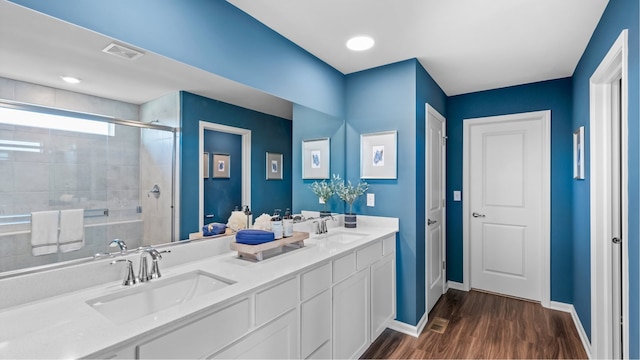 bathroom featuring vanity, a shower with shower door, and wood-type flooring