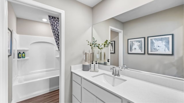 bathroom featuring vanity, hardwood / wood-style floors, and  shower combination