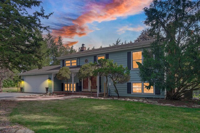 view of front of house featuring a garage and a yard