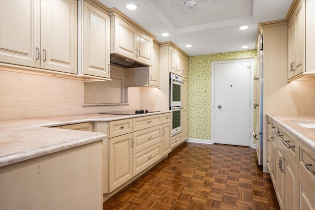 kitchen with black electric cooktop, double oven, light stone countertops, and dark parquet flooring