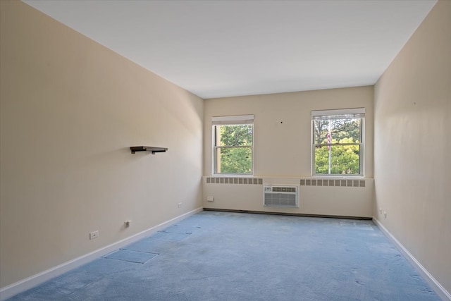 unfurnished room featuring radiator, a wall unit AC, and light colored carpet