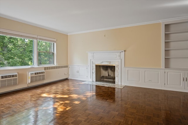 unfurnished living room featuring built in features, ornamental molding, parquet floors, a premium fireplace, and a wall mounted air conditioner