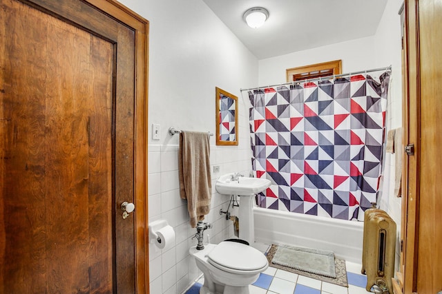 bathroom with radiator heating unit, a sink, shower / bath combination with curtain, tile walls, and toilet