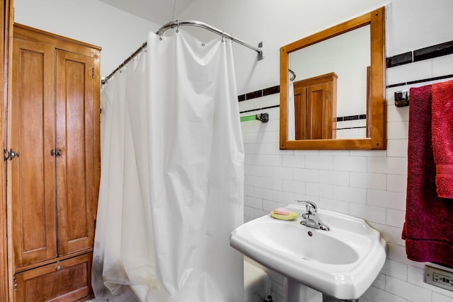 full bathroom with tile walls, a shower with curtain, and a sink