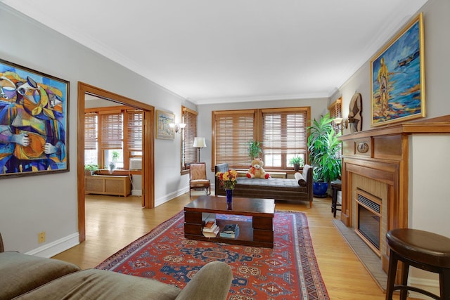 living area featuring baseboards, a fireplace with flush hearth, light wood-style flooring, and ornamental molding