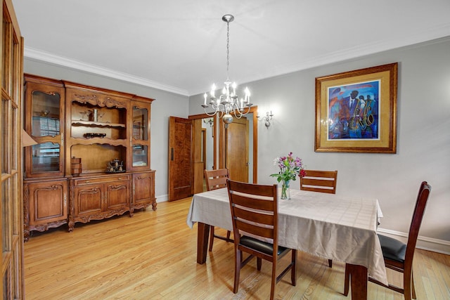 dining area with light wood-style flooring, baseboards, an inviting chandelier, and ornamental molding