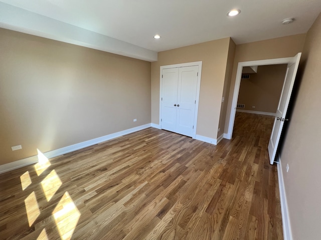 unfurnished bedroom with hardwood / wood-style flooring and a closet