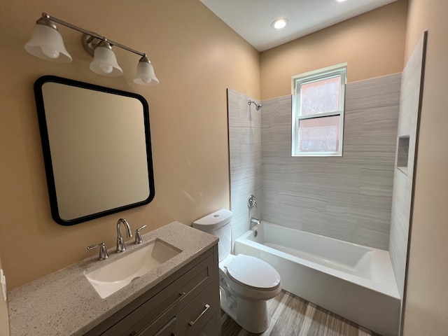 full bathroom with tiled shower / bath combo, vanity, toilet, and wood-type flooring