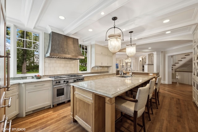 kitchen featuring a large island, wall chimney exhaust hood, high end stainless steel range oven, and hardwood / wood-style floors