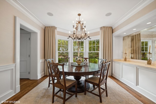 dining area with ornamental molding, dark hardwood / wood-style flooring, and a notable chandelier