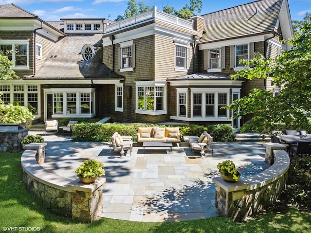 back of property with an outdoor living space and a patio