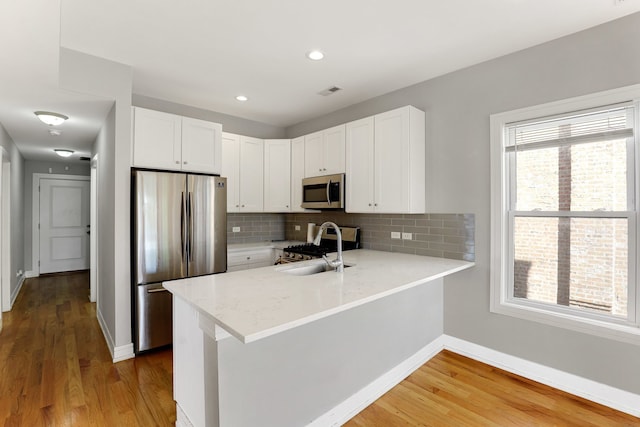 kitchen featuring white cabinetry, hardwood / wood-style floors, and appliances with stainless steel finishes