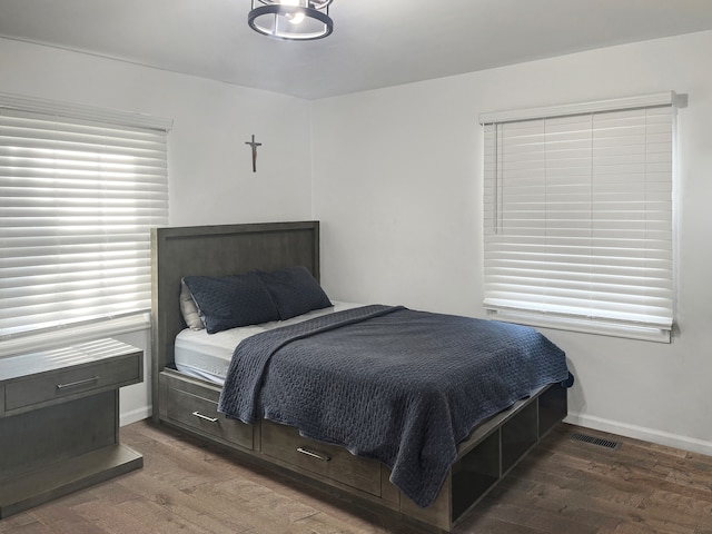 bedroom with dark hardwood / wood-style flooring