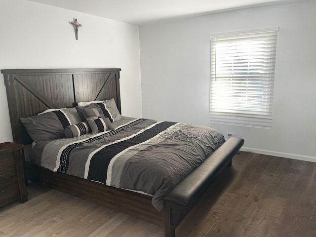 bedroom with multiple windows and dark hardwood / wood-style floors