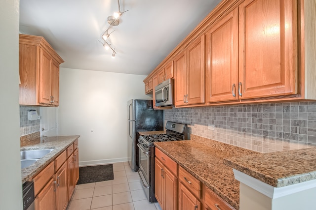 kitchen featuring tasteful backsplash, light stone countertops, stainless steel appliances, and light tile patterned flooring