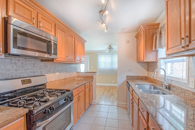 kitchen featuring rail lighting, sink, ceiling fan, appliances with stainless steel finishes, and light tile patterned flooring