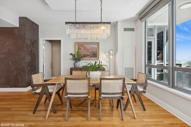 dining room with light wood-type flooring and a chandelier