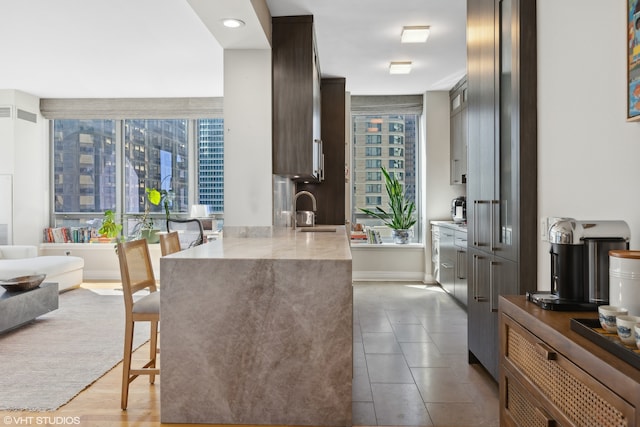 kitchen with a breakfast bar, light hardwood / wood-style floors, and sink