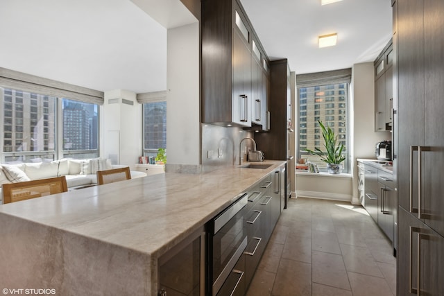 kitchen featuring dark tile patterned floors, a wealth of natural light, sink, and stainless steel microwave