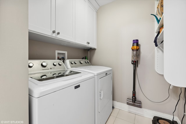 laundry area featuring separate washer and dryer, cabinets, and light tile patterned flooring