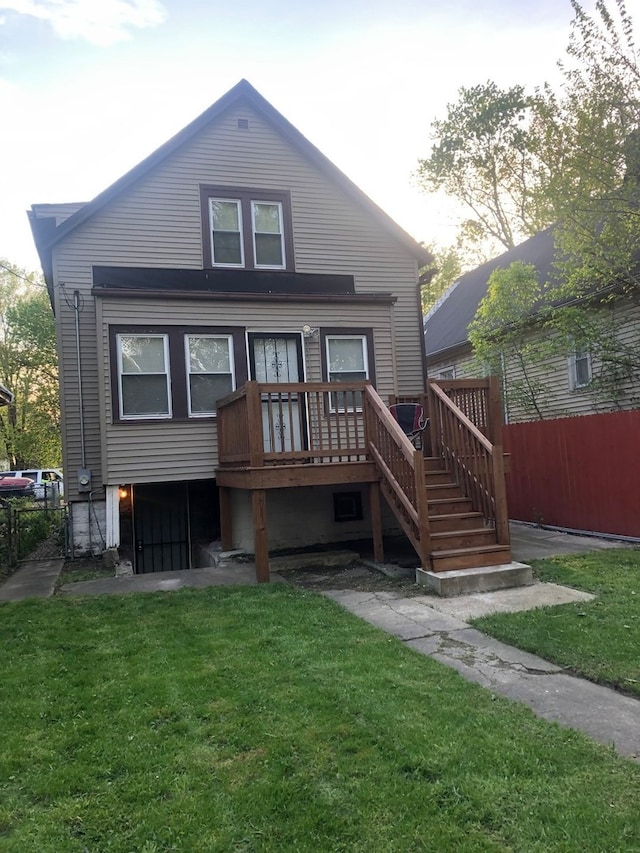 rear view of property featuring a lawn and a deck