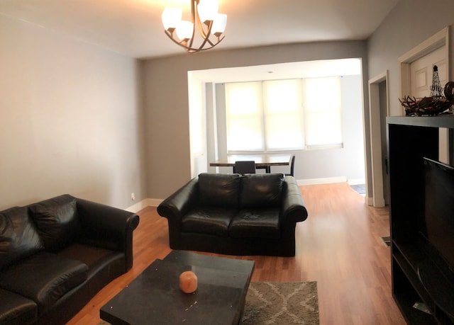 living room featuring hardwood / wood-style flooring and an inviting chandelier