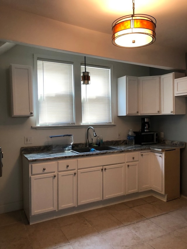 kitchen with sink, light tile patterned floors, and white cabinets