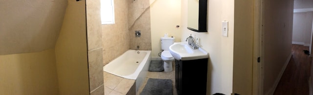 full bathroom with tiled shower / bath combo, vanity, and toilet