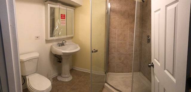 bathroom featuring tile patterned flooring, toilet, and a shower with shower door