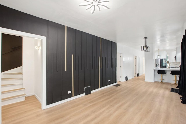 living area with light wood finished floors, visible vents, and stairs