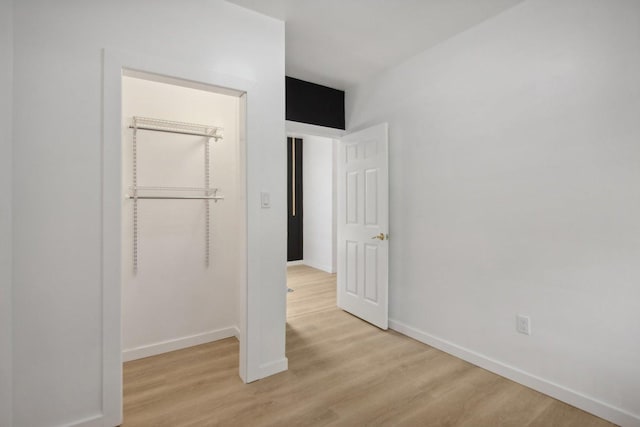 unfurnished bedroom with baseboards and light wood finished floors