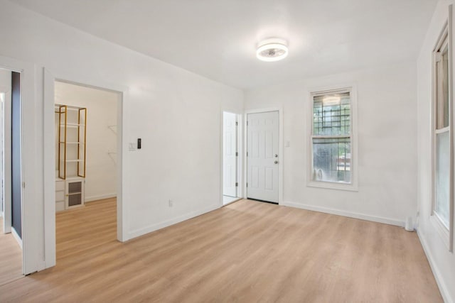 interior space with baseboards and light wood finished floors