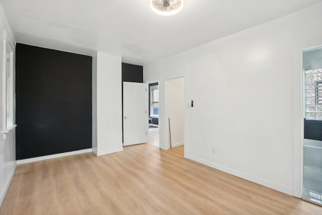 unfurnished room with light wood finished floors and baseboards