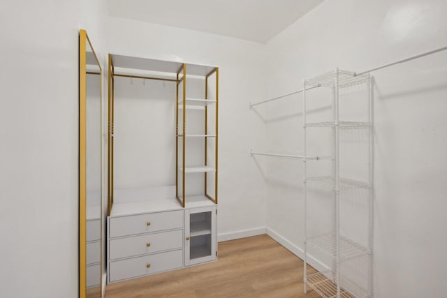 walk in closet with light hardwood / wood-style floors