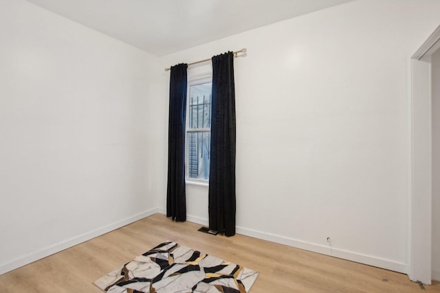 empty room featuring baseboards and light wood-style floors