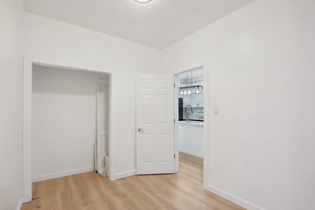 unfurnished bedroom featuring sink and light hardwood / wood-style flooring