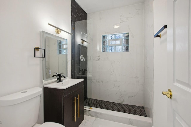 bathroom featuring vanity, toilet, marble finish floor, and a marble finish shower