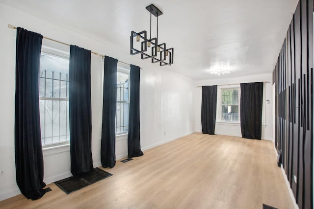 spare room featuring visible vents, light wood-style floors, and baseboards